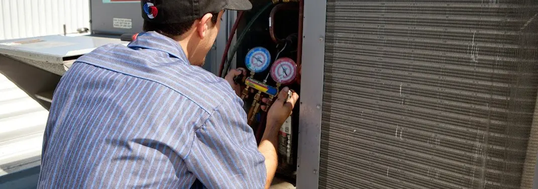 HVAC technician servicing a condenser unit in Chestnut Ridge