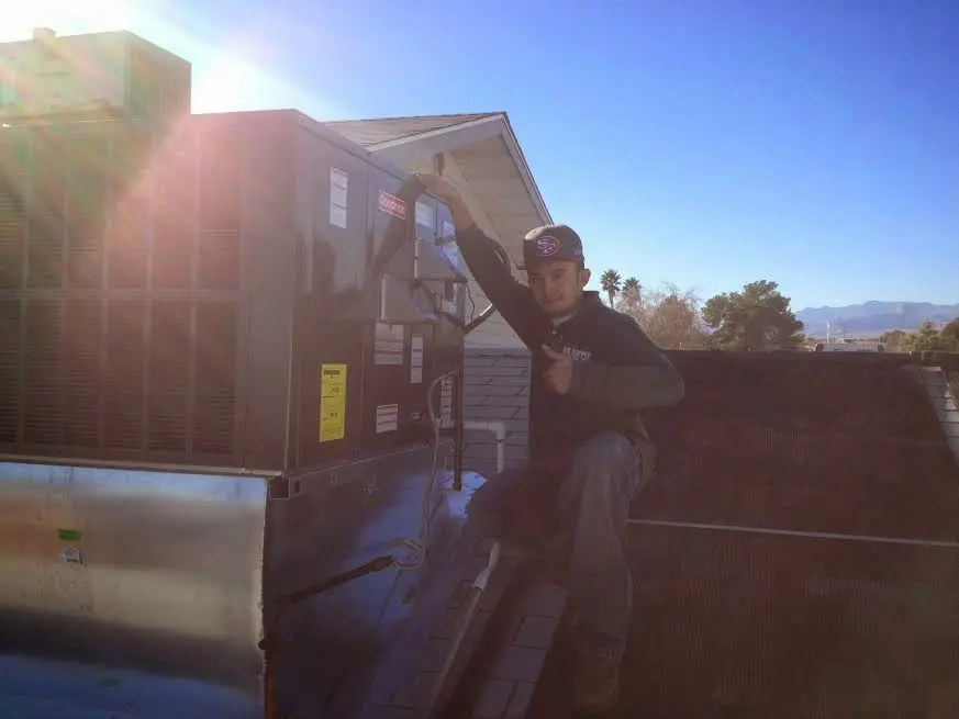 HVAC technician performing AC Tune-Up on a rooftop unit in Chestnut Ridge